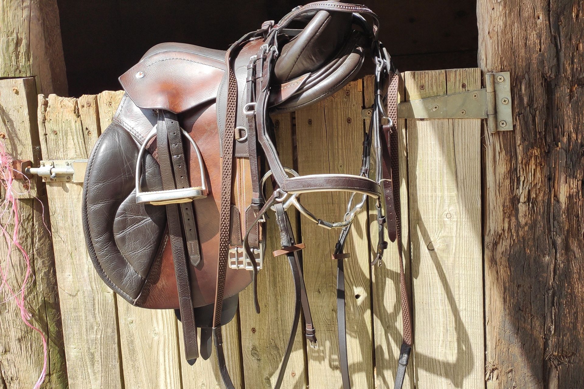 leather horse saddle on a wooden door